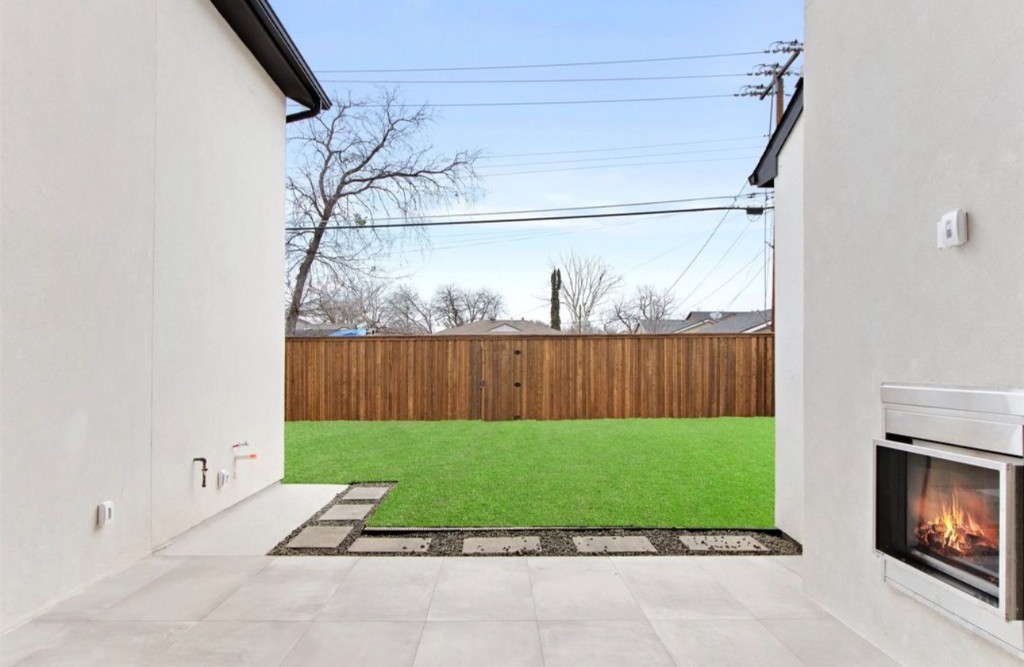 Family-sized backyard with lawn and outdoor fireplace